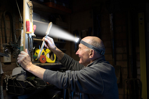 a man wearing an Energizer Vision HD+ Focus Industrial Headlamp organizing his tools