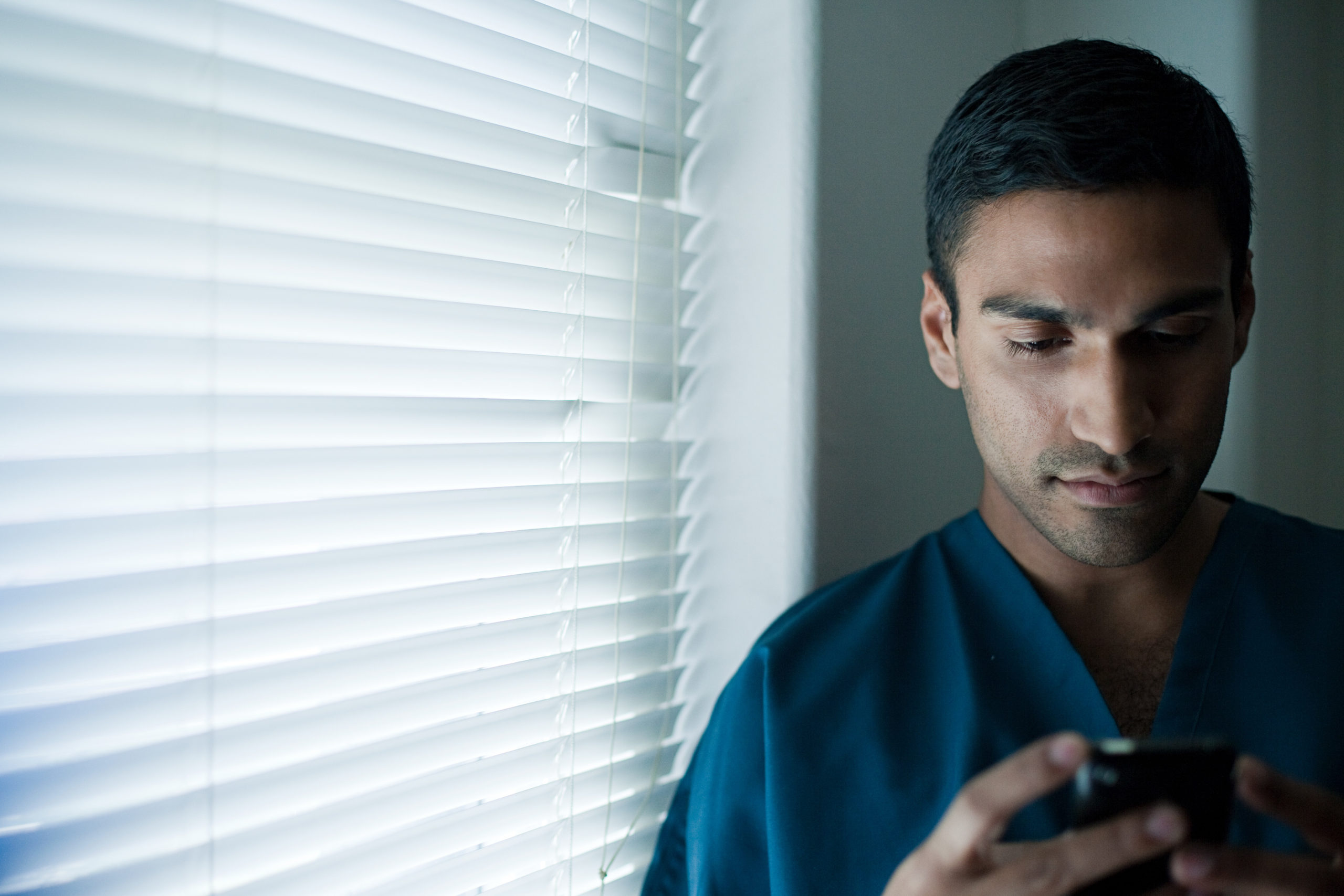 a male doctor using pager by the window
