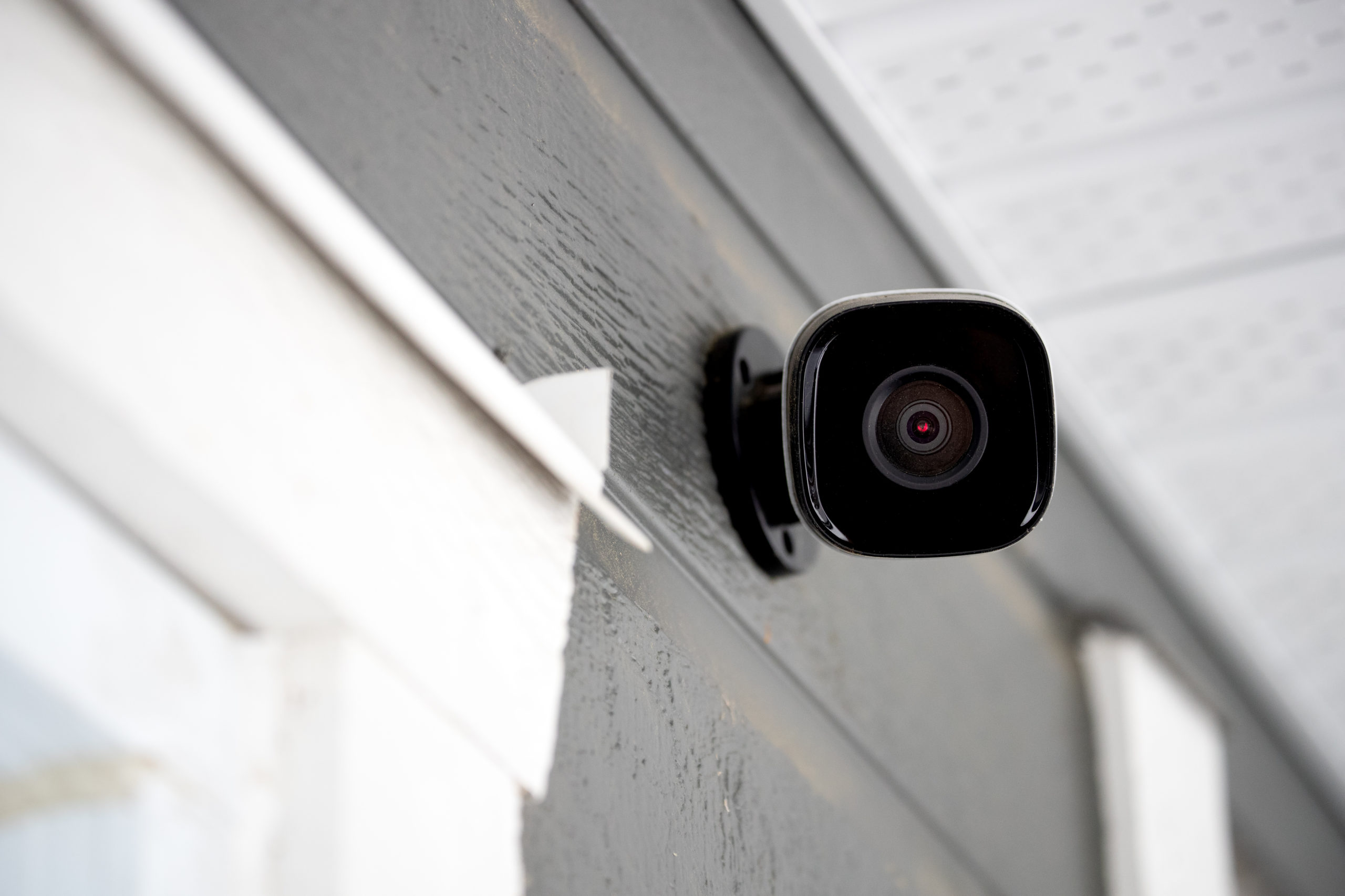 a black stick up camera on the house wall