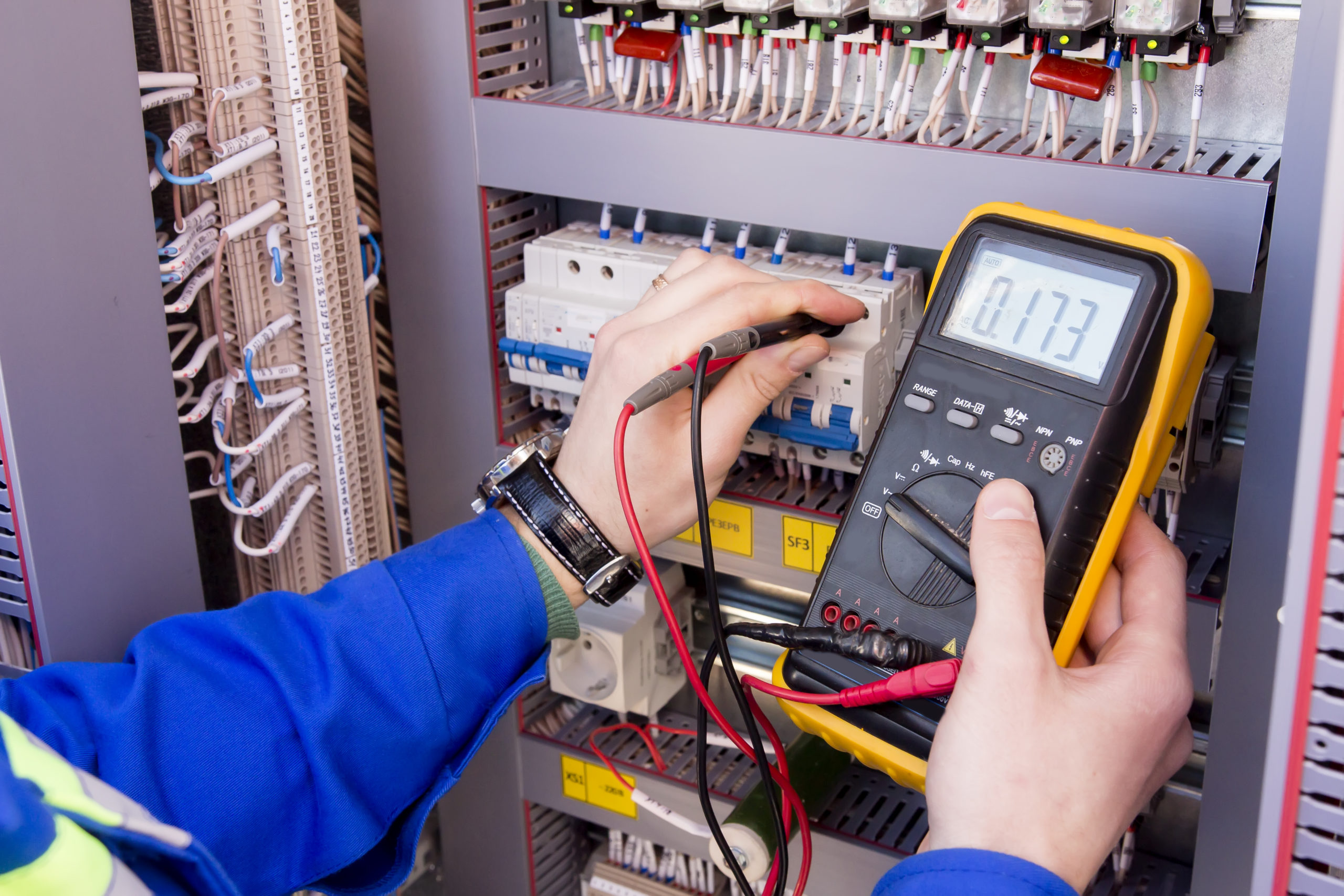 an electrician measuring voltage with a multimeter